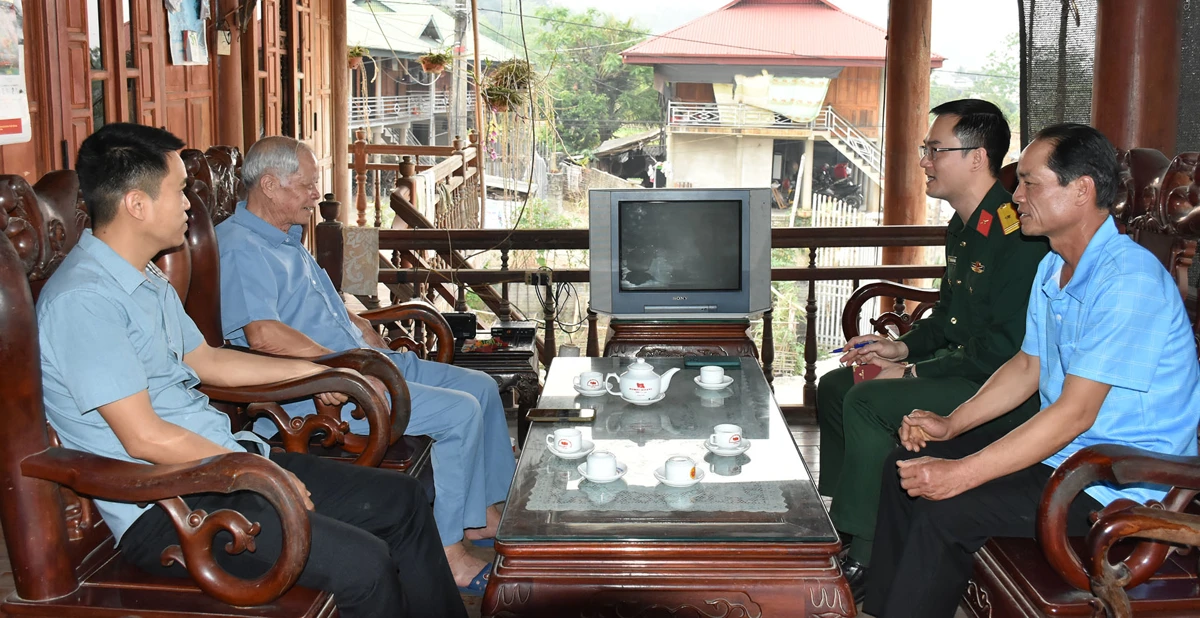 Village elder Luong Van Panh (second from the left) shared with a reporter from the People's Army Newspaper about the lives of the local people.